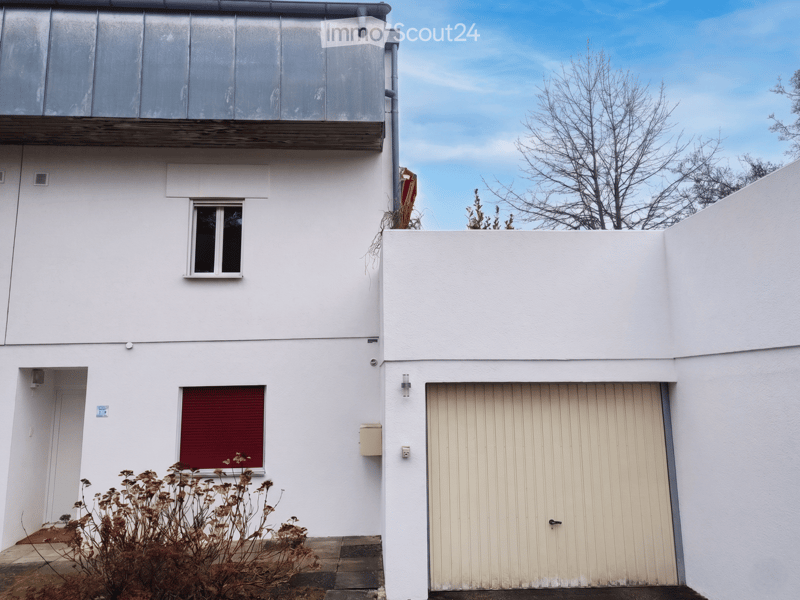 House. Two-story white house with a garage, windows, and a small balcony on the upper level.