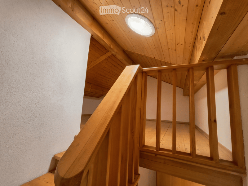 Corridor / Hallway. Wooden staircase with a curved handrail and a circular ceiling light, leading to an upper level with wooden flooring and white walls.