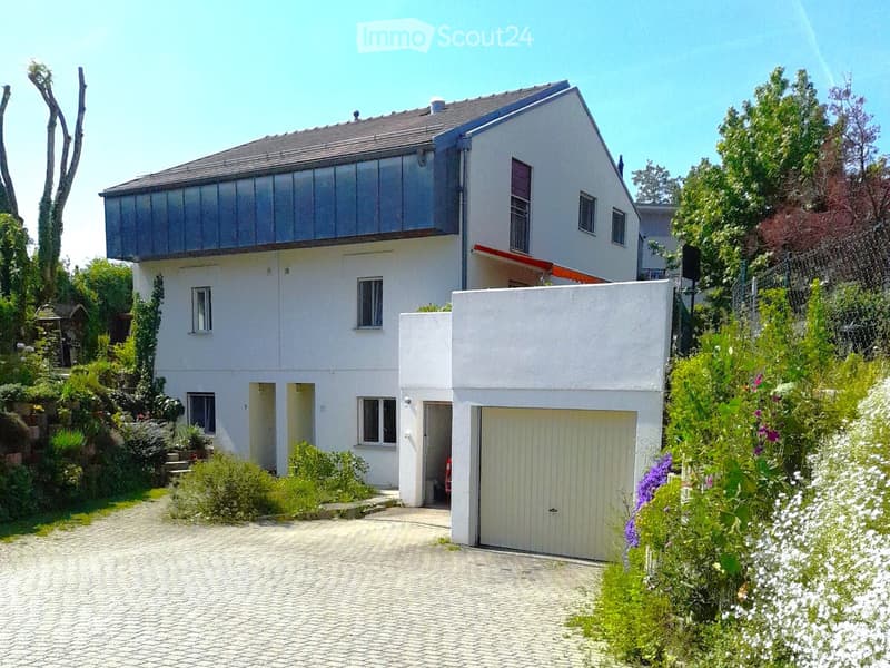 House. Two-story modern house with white exterior, garage, and well-maintained garden.
