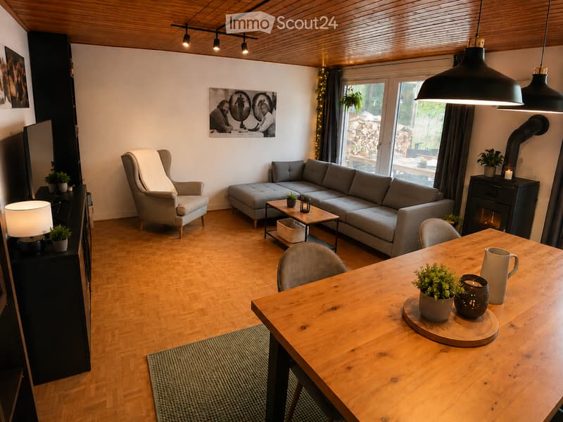 Modern living room with wooden flooring, grey sectional sofa, armchair, coffee table, dining table, and fireplace.