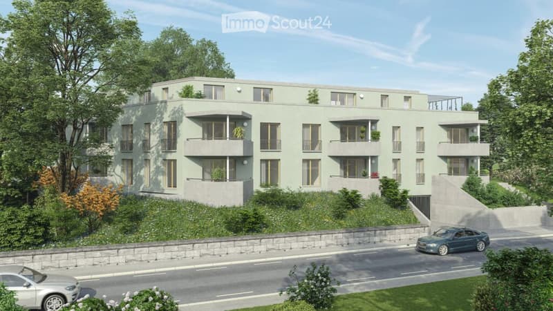 Modern multi-story residential building with balconies, surrounded by greenery and a road with parked cars.