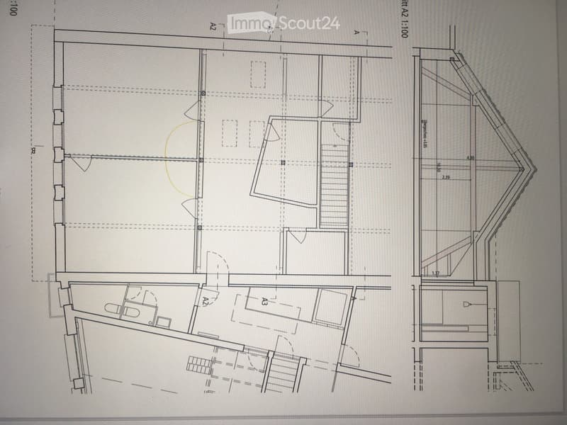Floor plan of a residential building with multiple rooms, including a living area, bedrooms, bathrooms, and a staircase leading to an upper level.