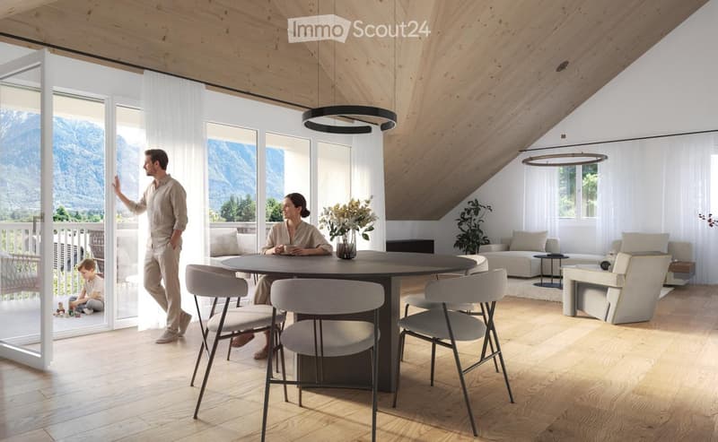 Bright, modern living and dining area with wooden floors, large windows, and a view of mountains. Features a round dining table with chairs, a sofa, coffee table, and decorative vase with flowers.