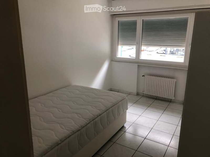 small room, white tile floor, single bed, radiator, window