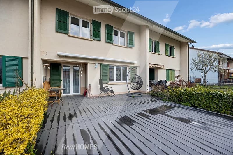 2 story house, beige exterior, green shutters, wooden deck, outdoor furniture