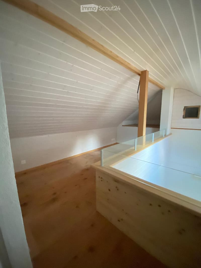 Modern, minimalist hallway with wooden walls, a glass railing, and a staircase leading upwards.