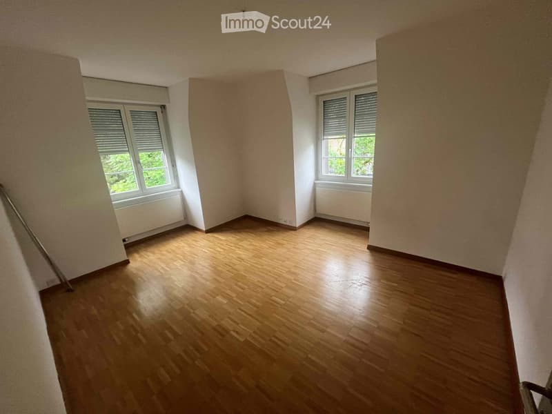 Empty room with wooden flooring, white walls, and two windows with blinds. No furniture or equipment present.