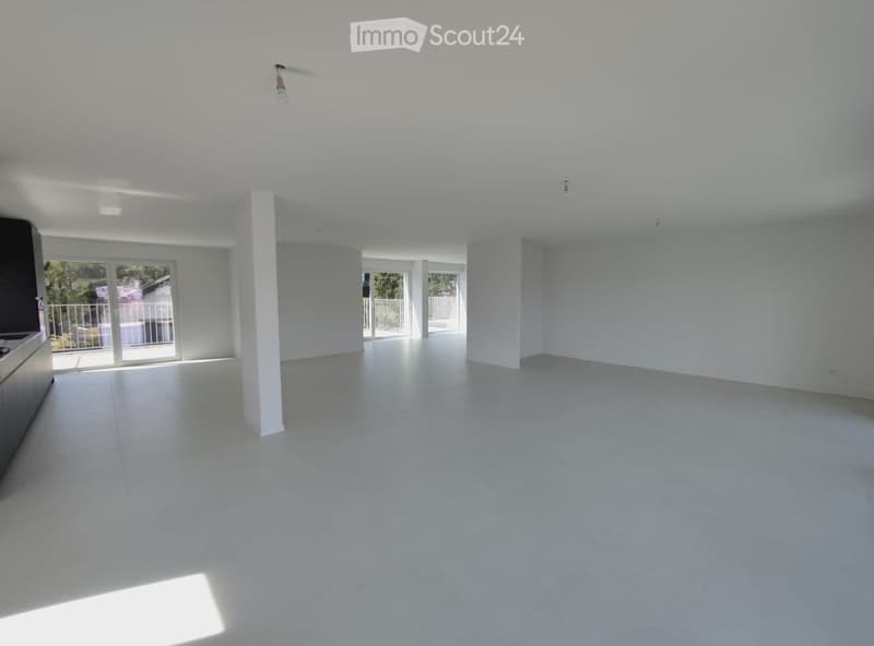 Empty room with white walls, white tiled floor, and large sliding glass doors leading to a balcony.