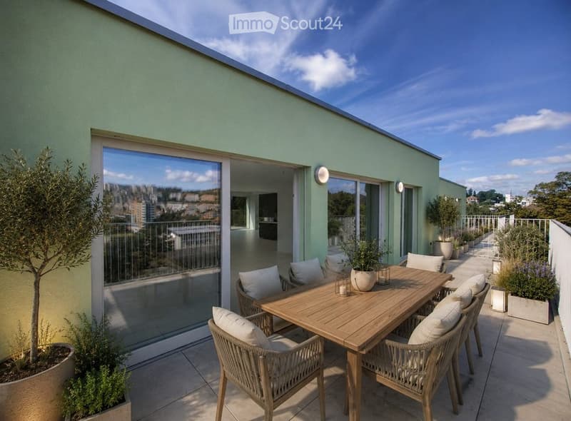 Rooftop terrace with wooden dining table, wicker chairs, potted plants, and city view.