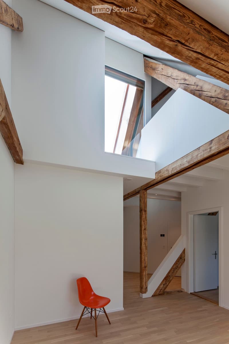 empty room, wooden beams, white walls, wooden floor, small orange chair