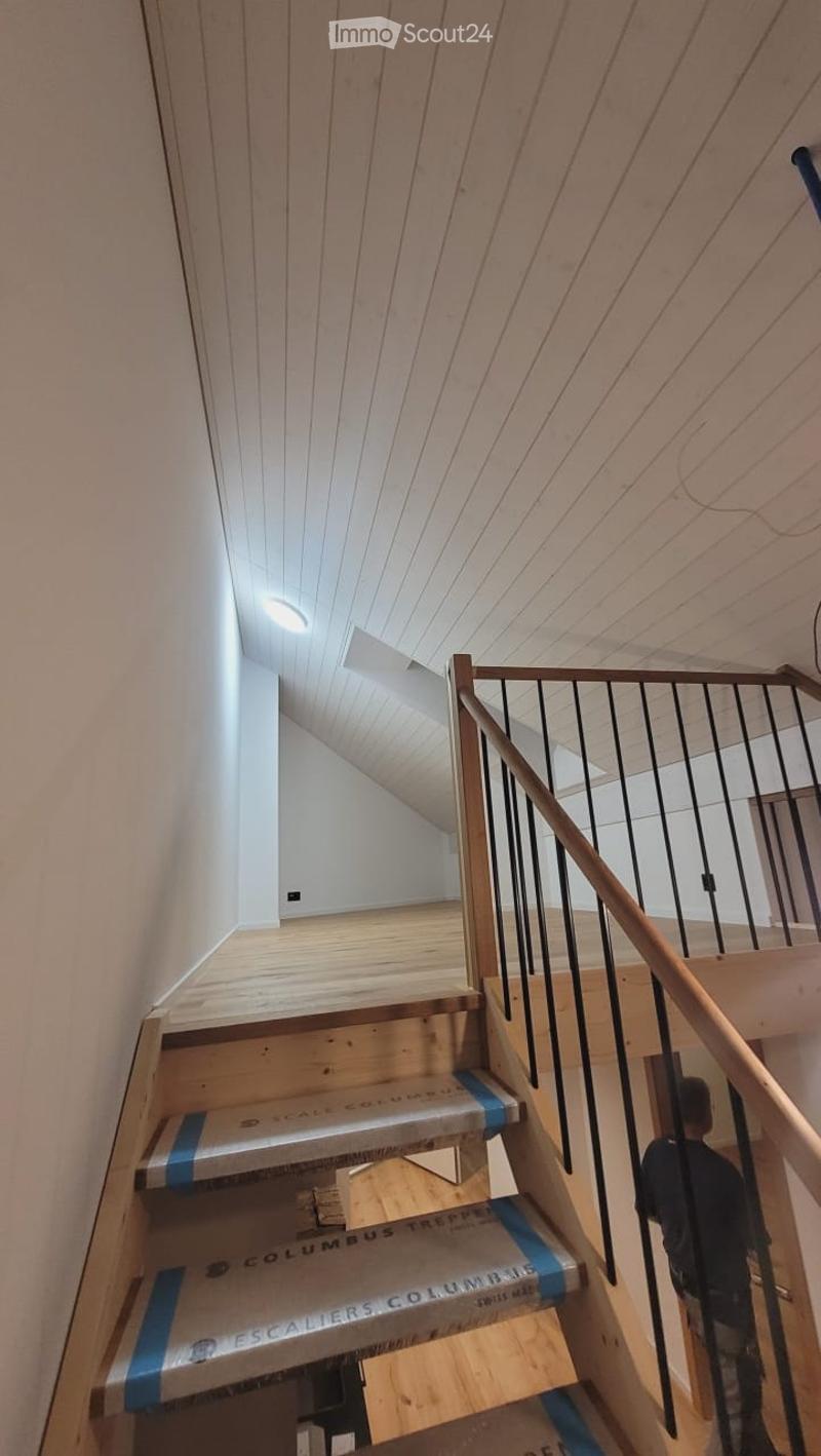 Wooden staircase with a modern railing and exposed wooden beams on the ceiling. The stairs are covered with protective plastic sheeting labeled "Columbus Trepper" and "Escaliers Columbus."