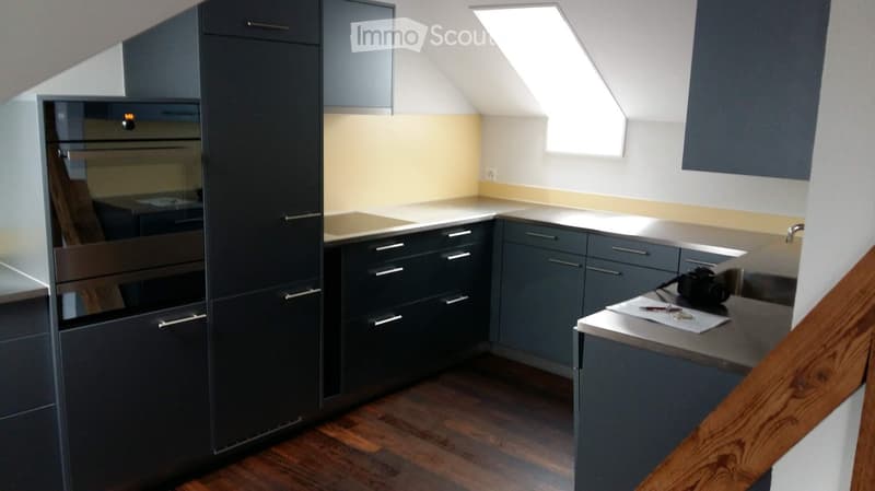 Kitchen. Modern kitchen with dark grey cabinets, stainless steel oven, and wooden flooring.