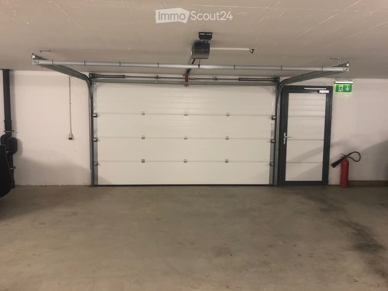 {"type": "Garage", "objects": [], "description": "Empty garage with a large white garage door, a smaller side door, and a fire extinguisher on the wall.", "localized_descriptions": {"EN": "Empty garage with a large white garage door, a smaller side door,