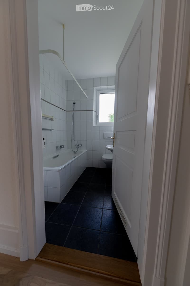 white bathtub, white toilet, white tiles, white walls, window