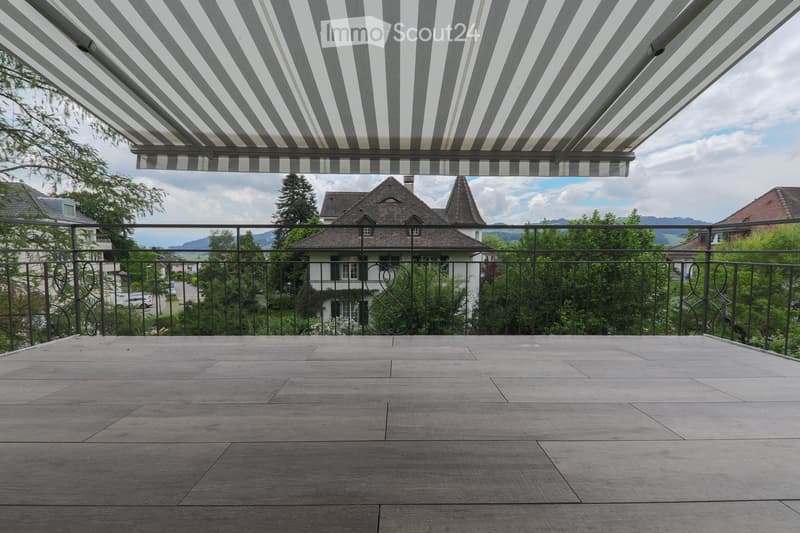 wooden floor, black railing, retractable awning, view of the house and mountains