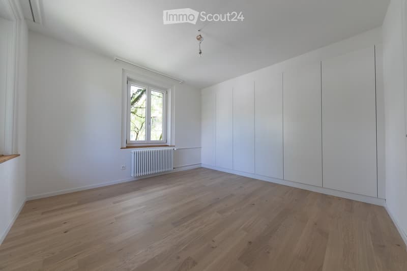 empty room, white walls, wooden floor, white radiator, window with white frame