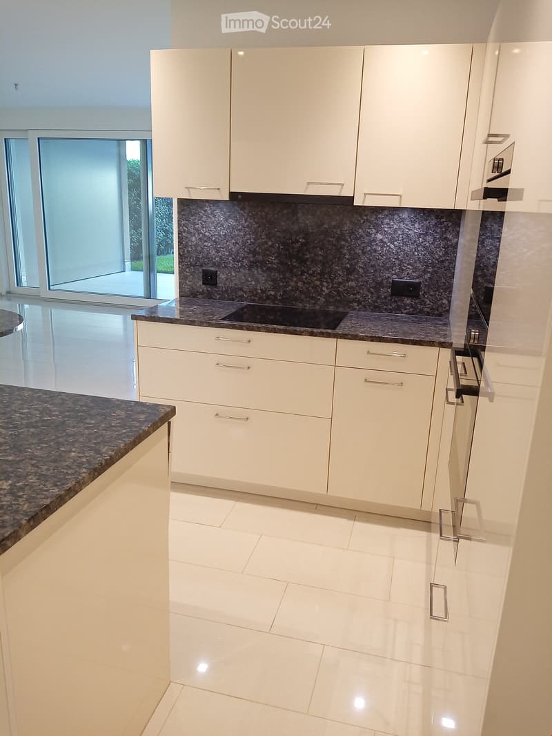 modern kitchen with white cabinets, granite countertops, tiled floor, glass doors leading to a patio