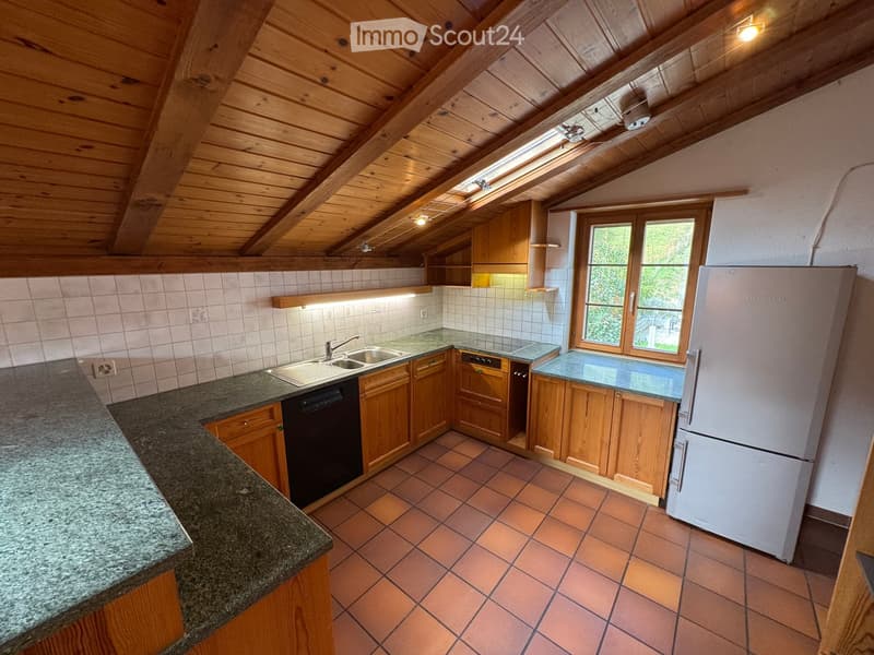 Kitchen with wooden cabinets, granite countertops, tiled floor, and a window overlooking the outdoors.