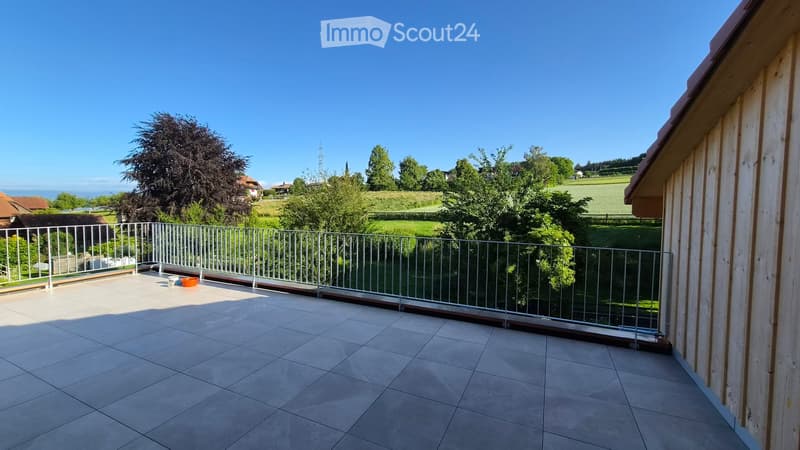 Balcony with tiled floor, metal railing, and scenic countryside view.