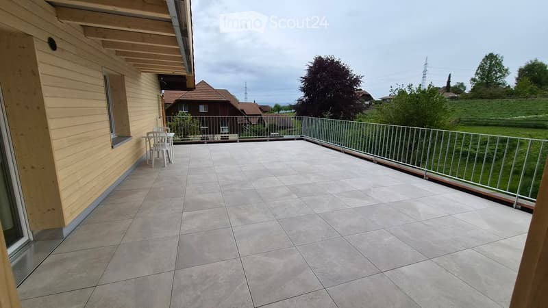 Balcony with tiled floor, metal railing, and a small table and chairs set.