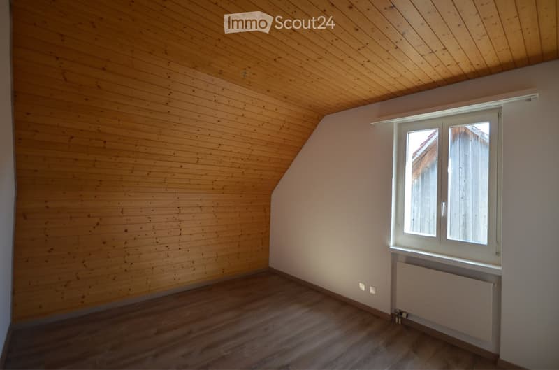 Empty room with wooden walls and ceiling, wooden floor, and a window with white frame. No furniture or equipment present.