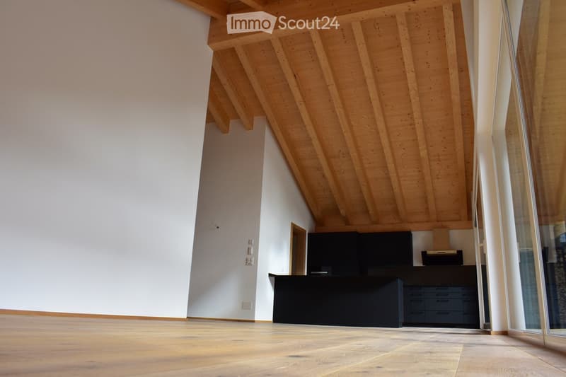 empty room with hardwood floors, white walls, wooden beams on the ceiling, and large windows