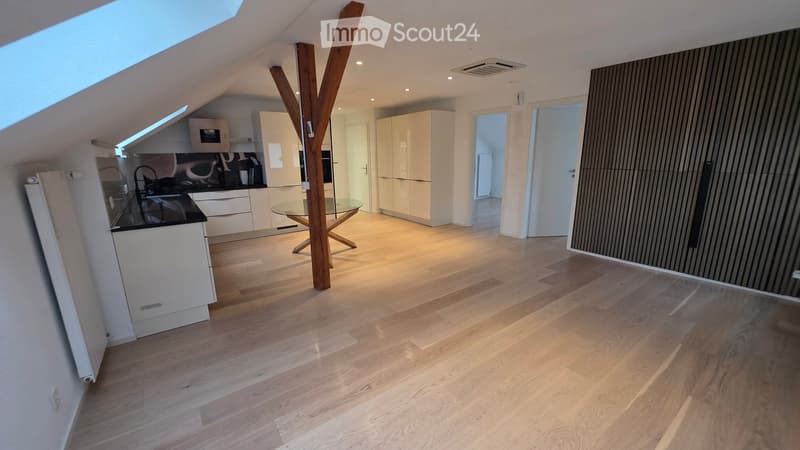 modern kitchen with wooden floor, white cabinets, glass table, wooden pillar, ceiling lights