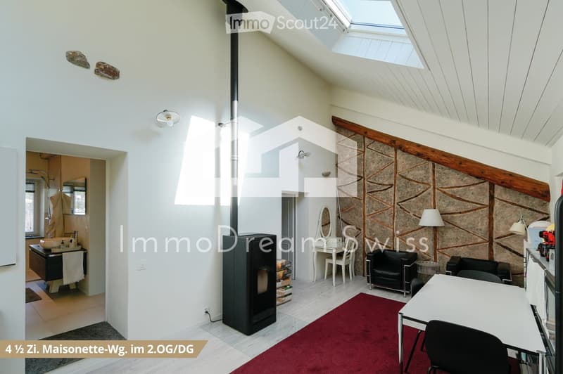 Bright, open living space with a modern fireplace, large skylight, exposed wooden beams, and a mix of contemporary and rustic decor including a sofa, chairs, a table, and a sink area.