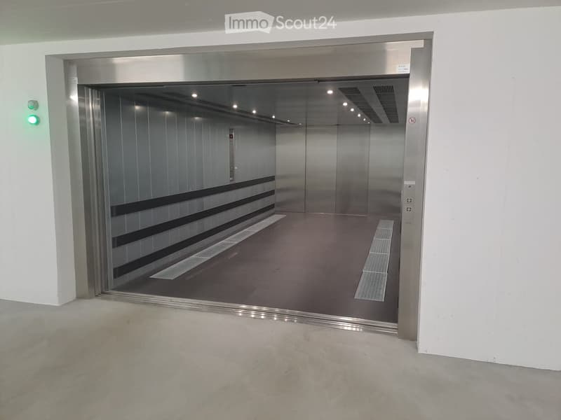 Empty hallway with a modern elevator entrance featuring stainless steel doors and a clean, minimalist design.