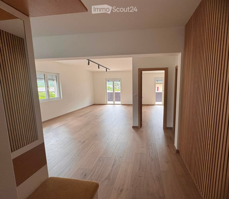 Empty room with wooden flooring, white walls, and large windows. No furniture or equipment present.