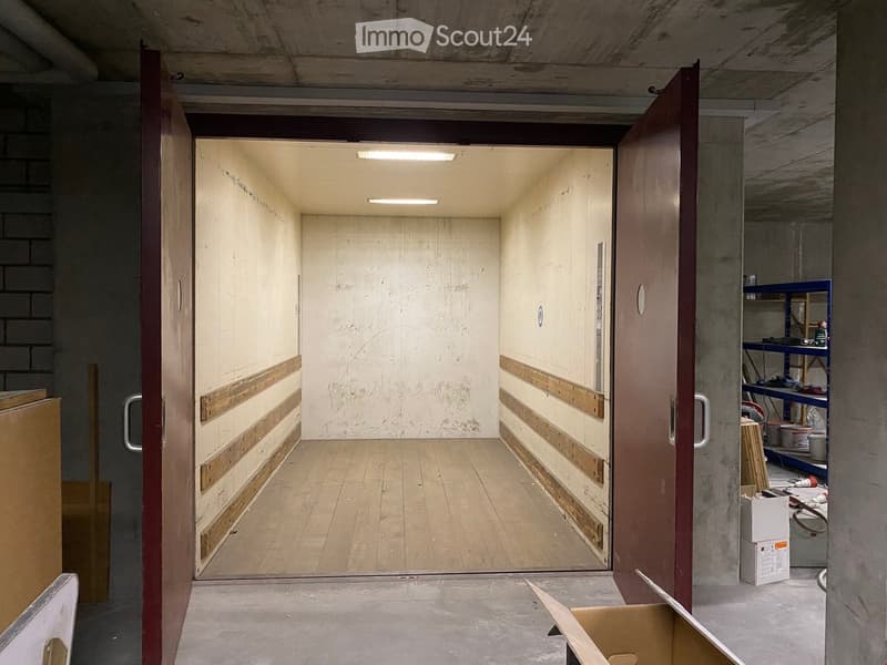 empty garage with wooden floor and concrete walls