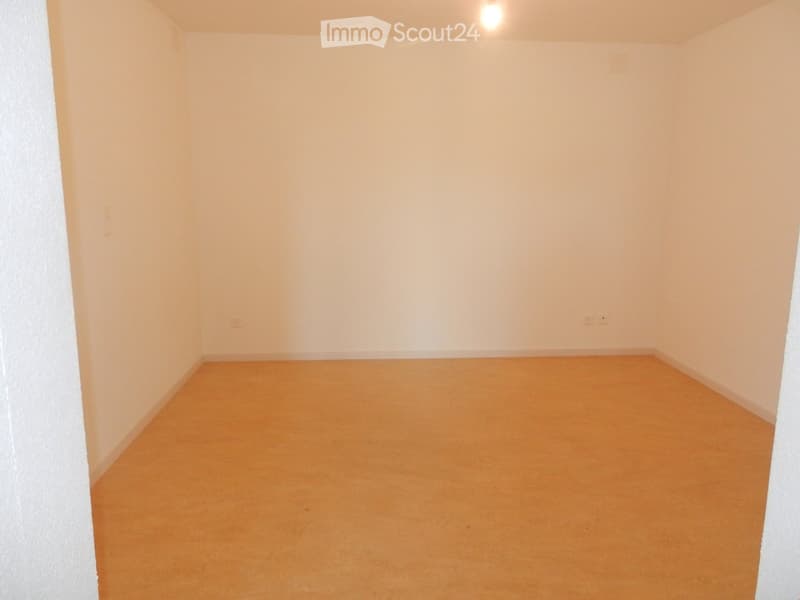 Empty room with light-colored walls and a smooth, light brown carpeted floor. No furniture or equipment is present.