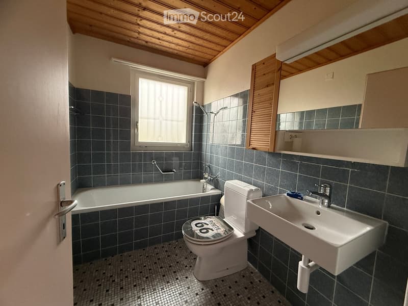 Bathroom with bathtub, toilet, sink, mirror, wooden ceiling