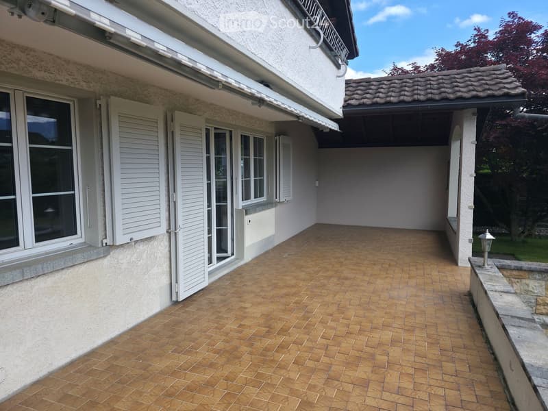 Balcony with wooden tiled flooring, white shutters, and a covered section with a tiled roof.