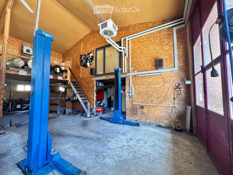 {"visible_features": ["Garage"], "type": "Garage", "objects": [], "description": "Garage with wooden walls, concrete floor, blue lift, and various tools and equipment stored on shelves and in the background.", "localized_descriptions": {"EN": "Garage with