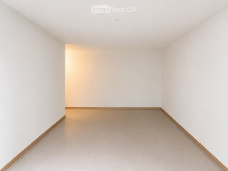 Empty room with white walls, light-colored carpet, and a small recessed ceiling light.