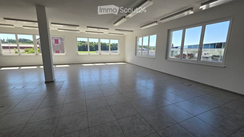 Empty room with tiled floor, large windows, and bright lighting. No furniture or equipment present.