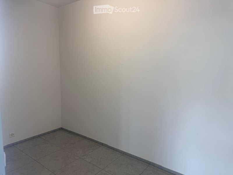Empty room with white walls and tiled floor, no furniture or equipment.