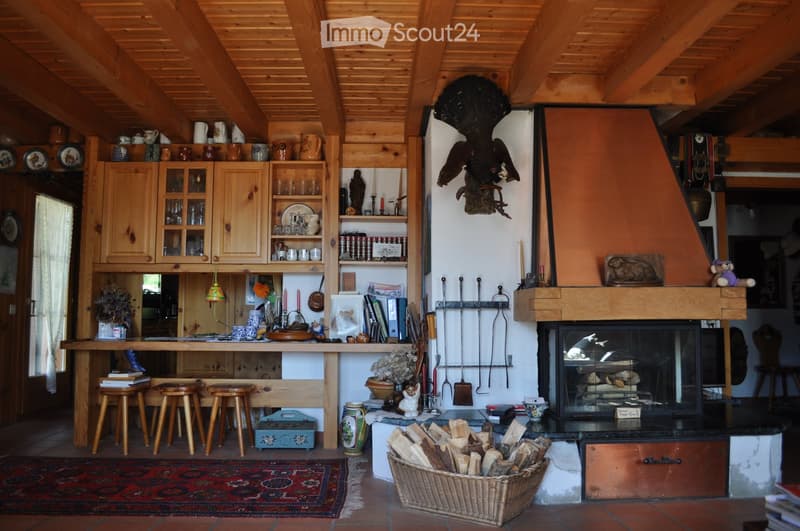 Cozy living room with wooden beams, fireplace, wooden cabinets, and various decorative items.