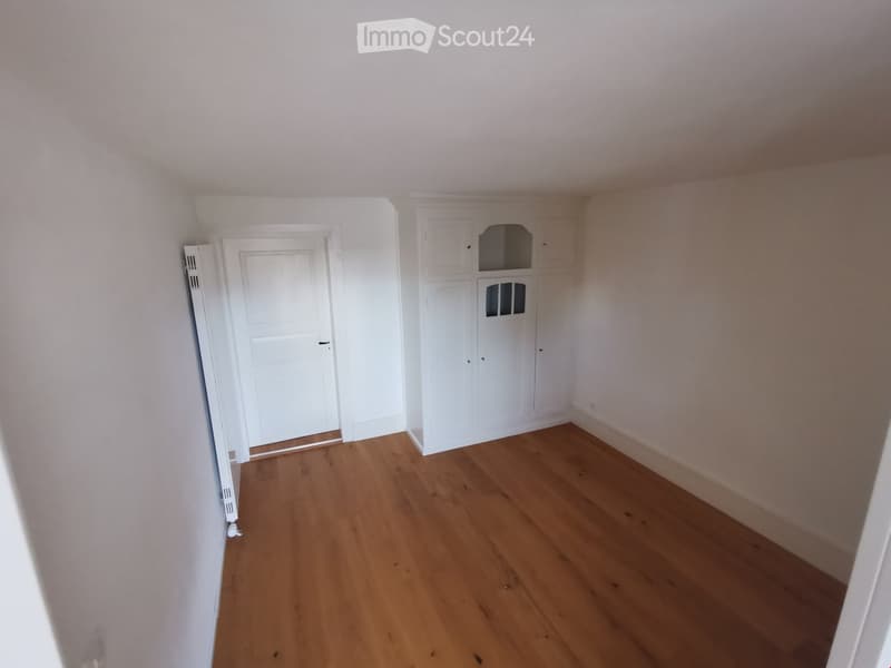 empty room, wooden floor, white walls, white door, white cabinets