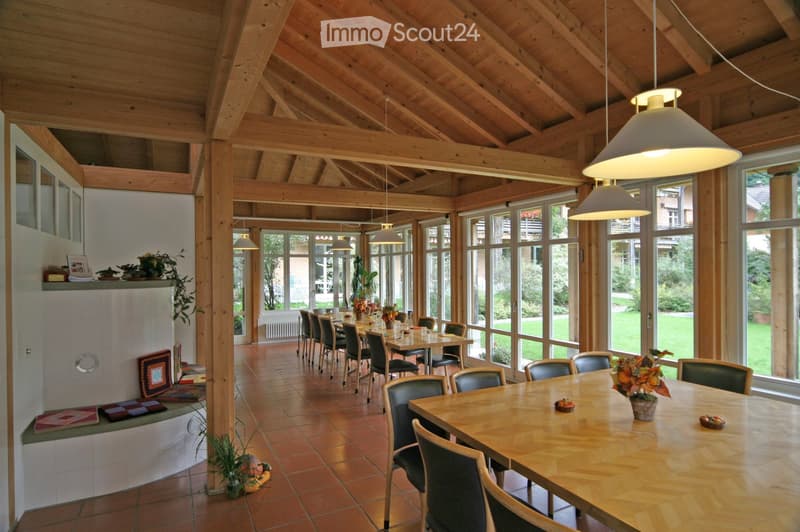 dining area with tables and chairs, wooden ceiling, floor, long windows, flower vase, cushions