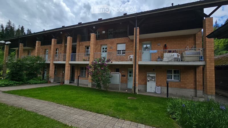 3 story apartment, brick wall, green lawn, 3 balconies