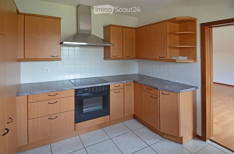 Modern kitchen with wooden cabinetry, white tiles, granite countertops, integrated oven, stove, dishwasher, and sink