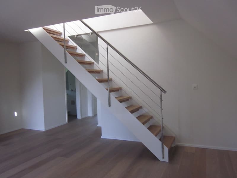 Interior view with staircase leading to raised ground floor, wooden flooring, white walls