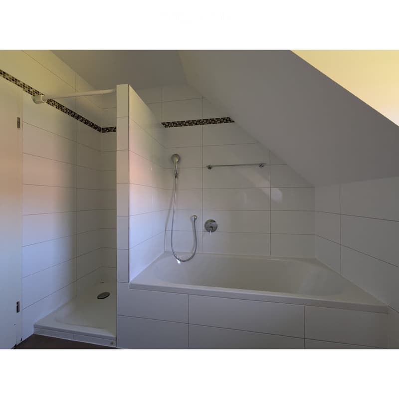 Bathroom. Modern bathroom with a bathtub and separate shower area, white tiles, and sleek fixtures.