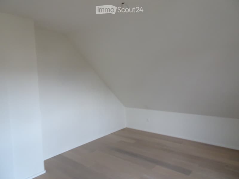 empty room, white walls, wooden floor, slanted ceiling