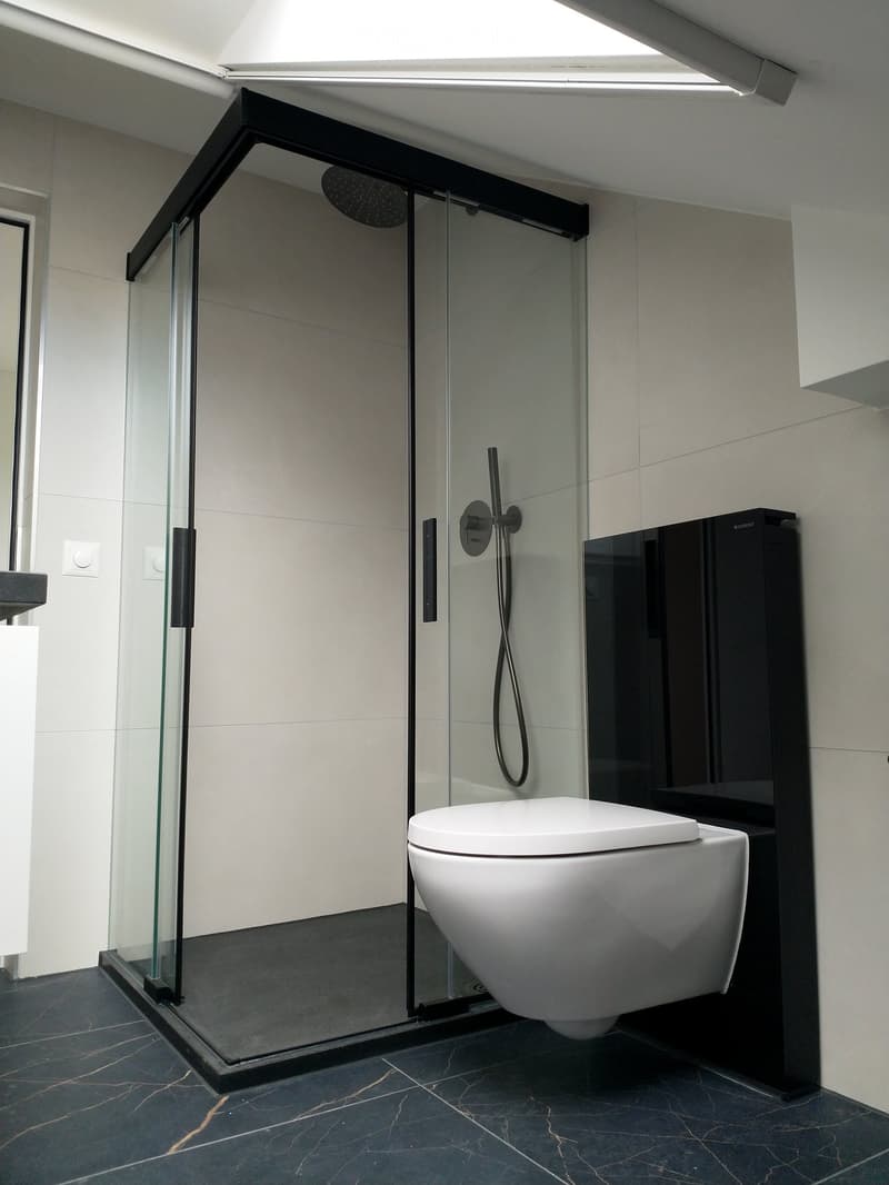 modern shower room, glass shower enclosure, black fixtures, modern white toilet, black tiled floor