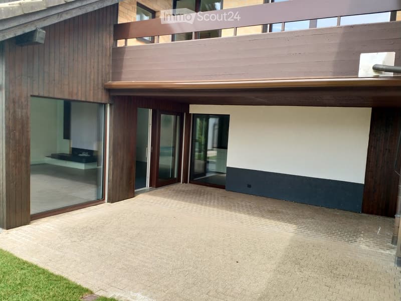 Balcony, brick and wooden exterior, paved entrance