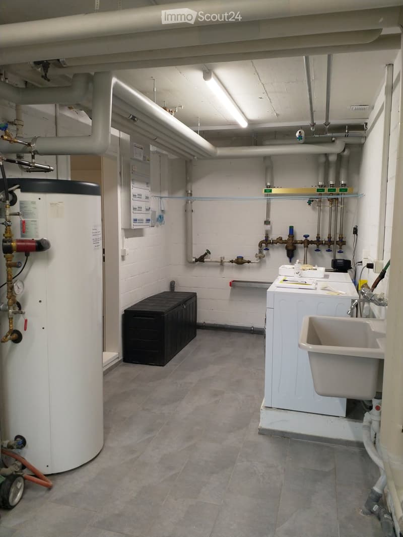 Laundry room with a washing machine, water heater, and sink