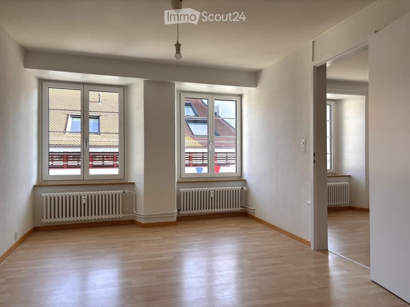 empty room, wooden floor, white walls, two large windows, two white radiators